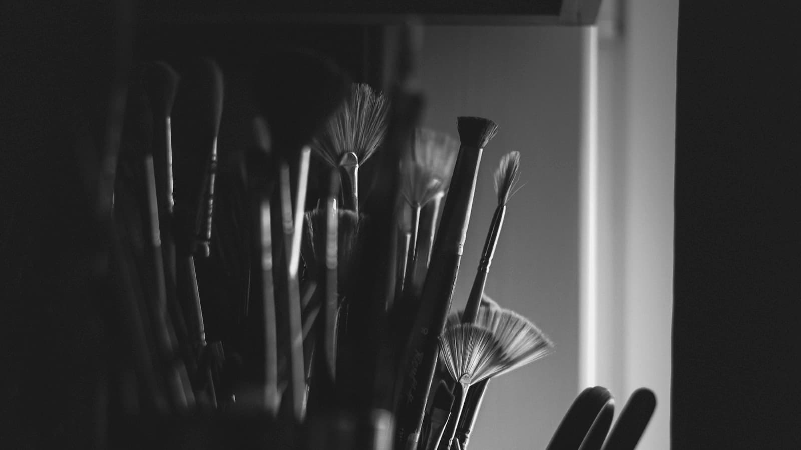 Black and white photograph of an artist's paint brushes in a studio