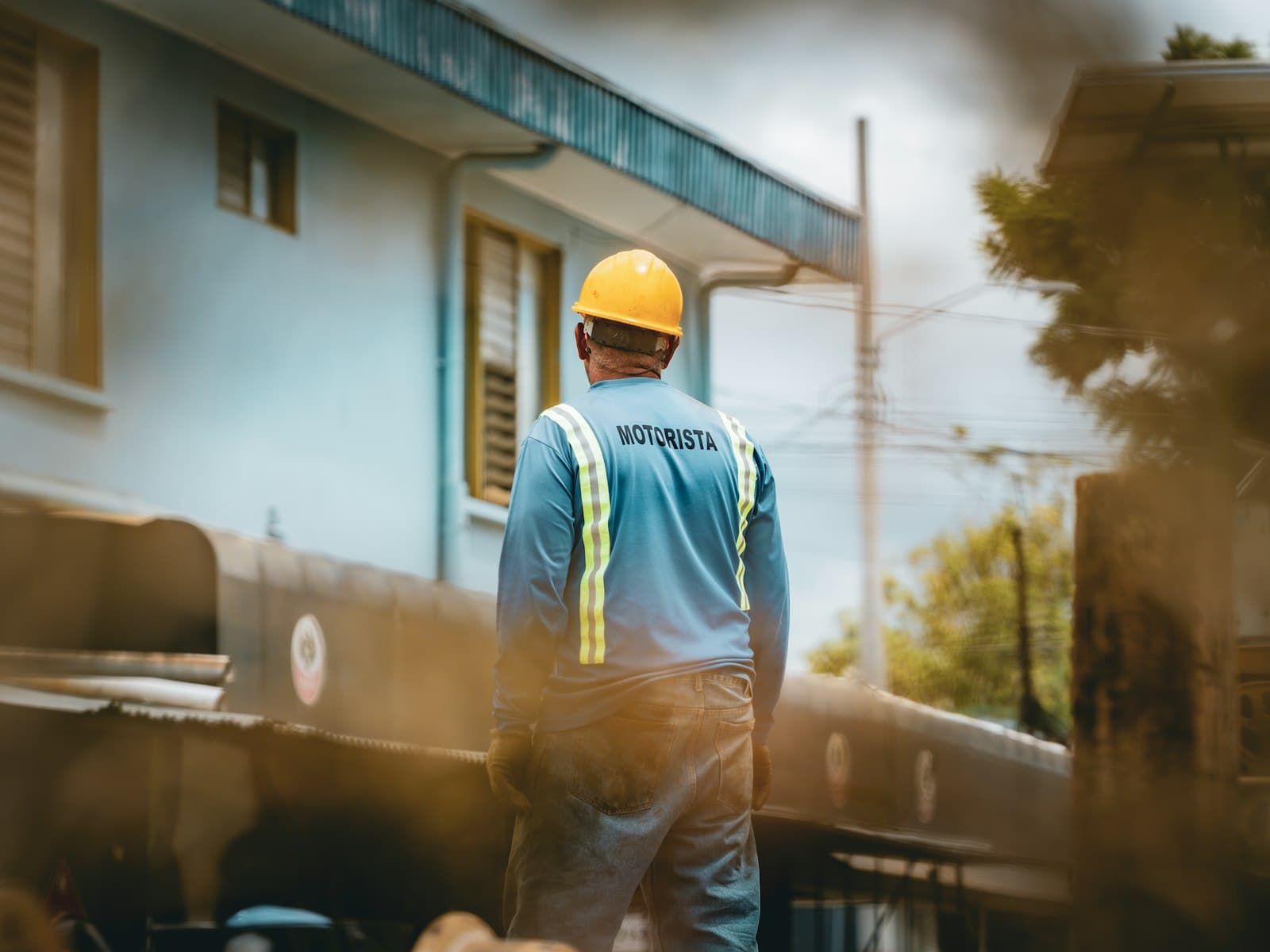 Worker in hard hat and safety vest looks away